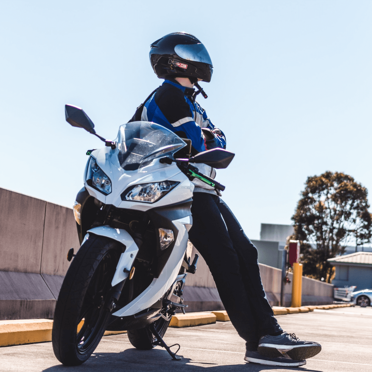 motorcyclist leaning against their bike